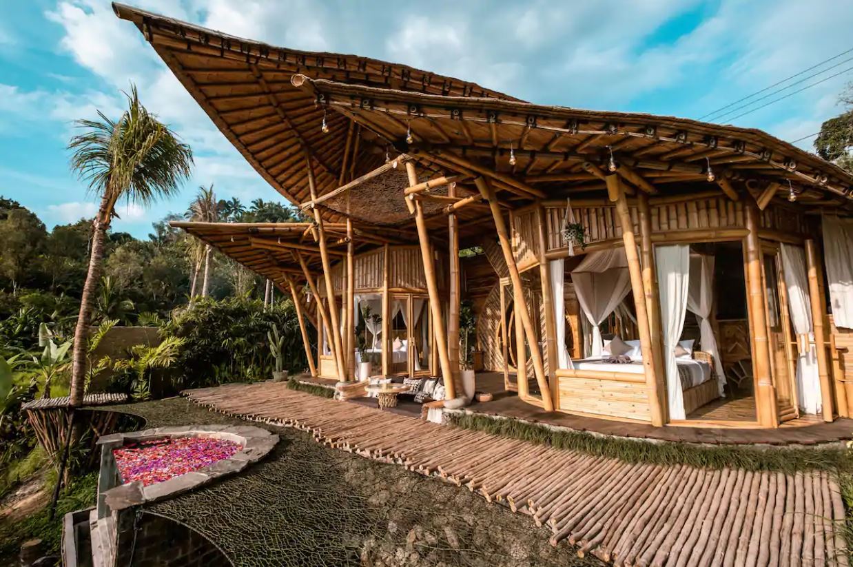El exterior de una casa de bambú al aire libre en Bali con un jacuzzi al aire libre