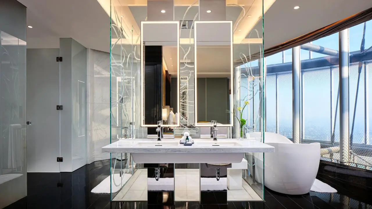 La moderna ducha de vidrio y la bañera con pedal magnolia tienen vistas al horizonte en la J Suite en el J Hotel Shanghai Tower.